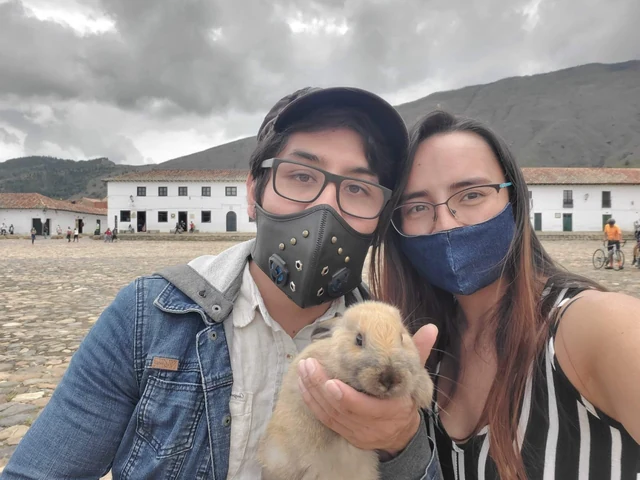 Coco en brazos, junto a sus dos familiares al aire libre.